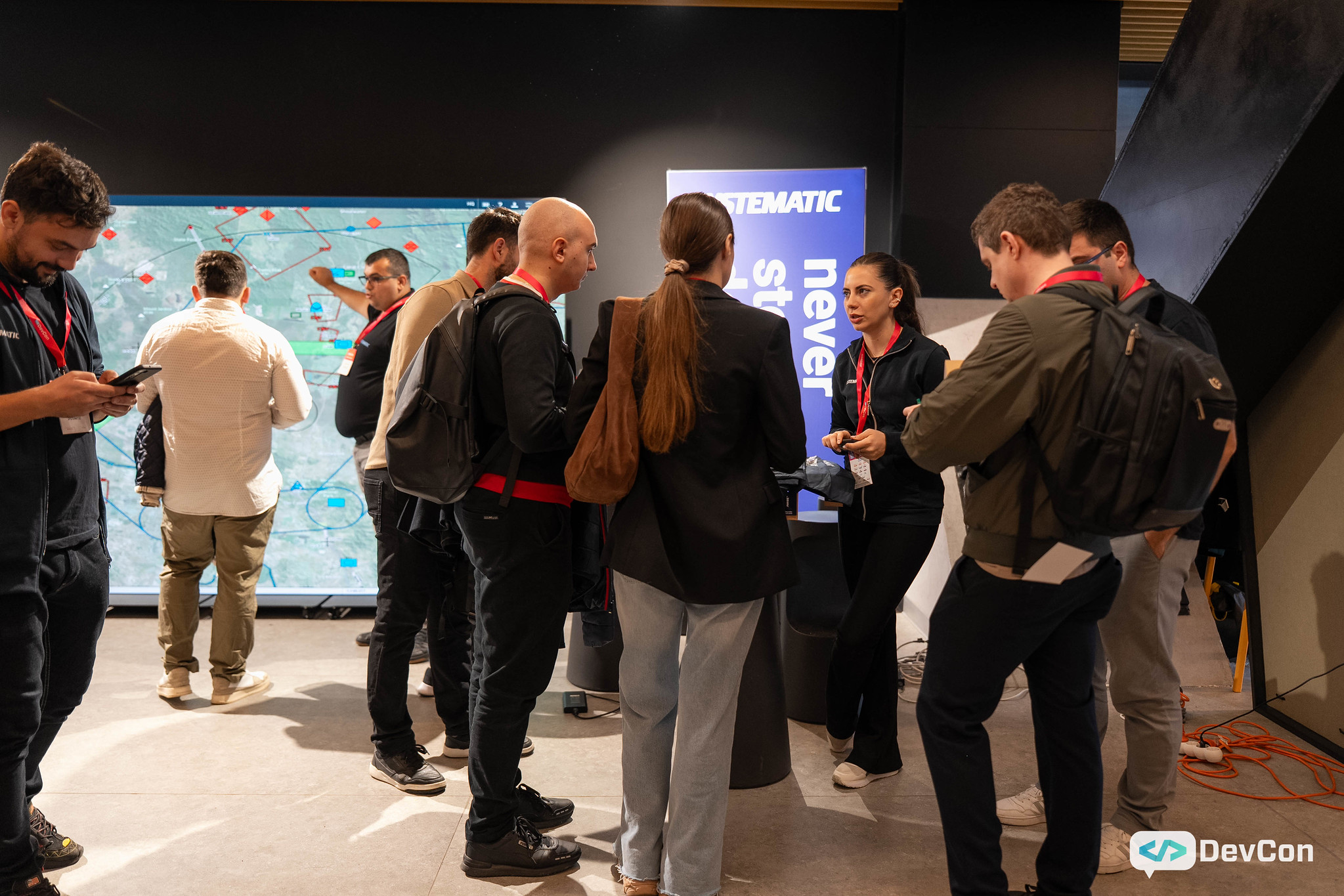 Group discussion near digital screen at event.