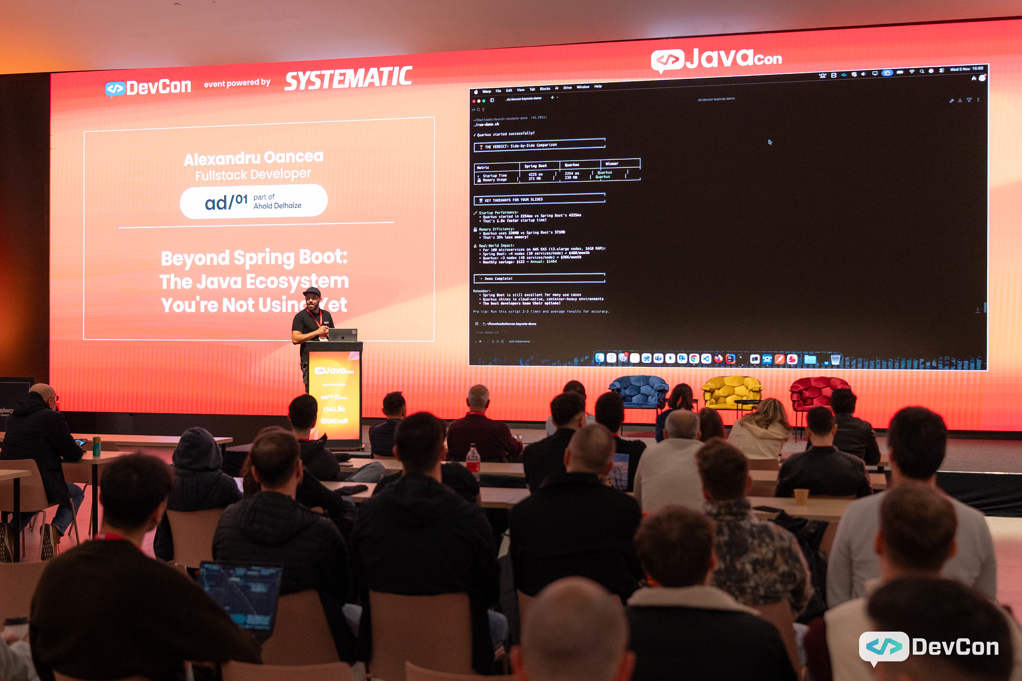 Speaker at Java conference on stage, audience seated.